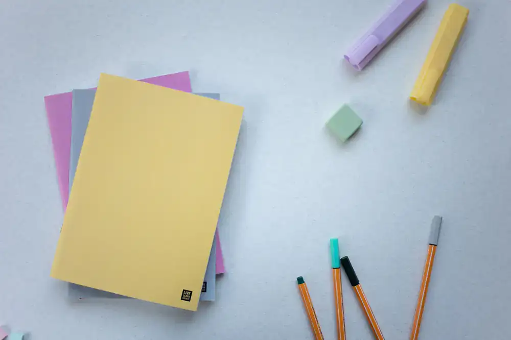 Notizbücher und Stifte auf einem Schreibtisch